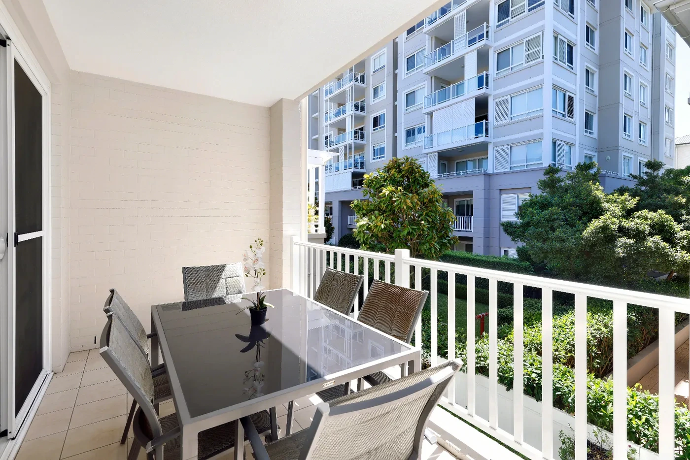 Private balcony with alfresco dining overlooking landscaped gardens at the Premium X Residence