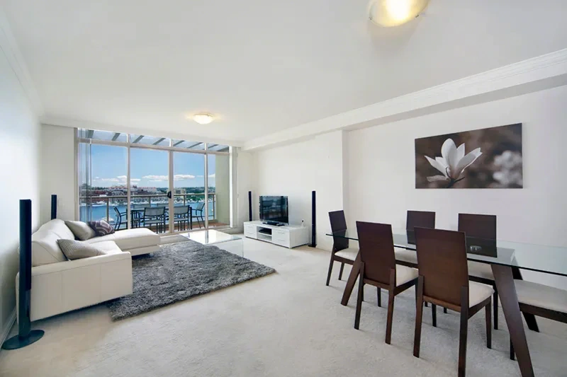 Open-plan penthouse living and dining area with harbour outlook in Rozelle