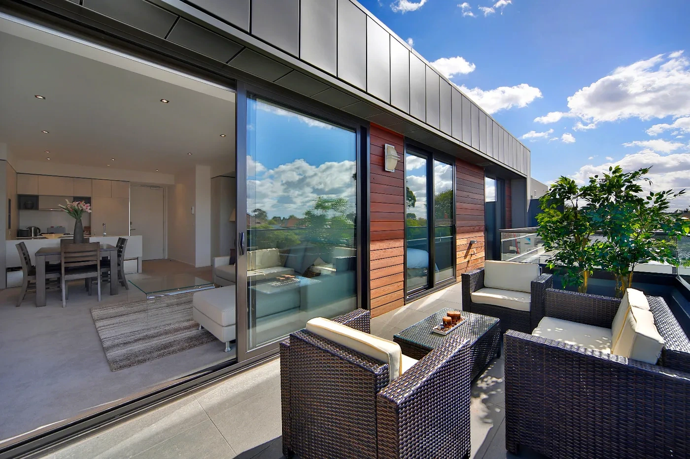 Living room and balcony with a treetop outlook at a Westprecinct serviced residence in Toorak